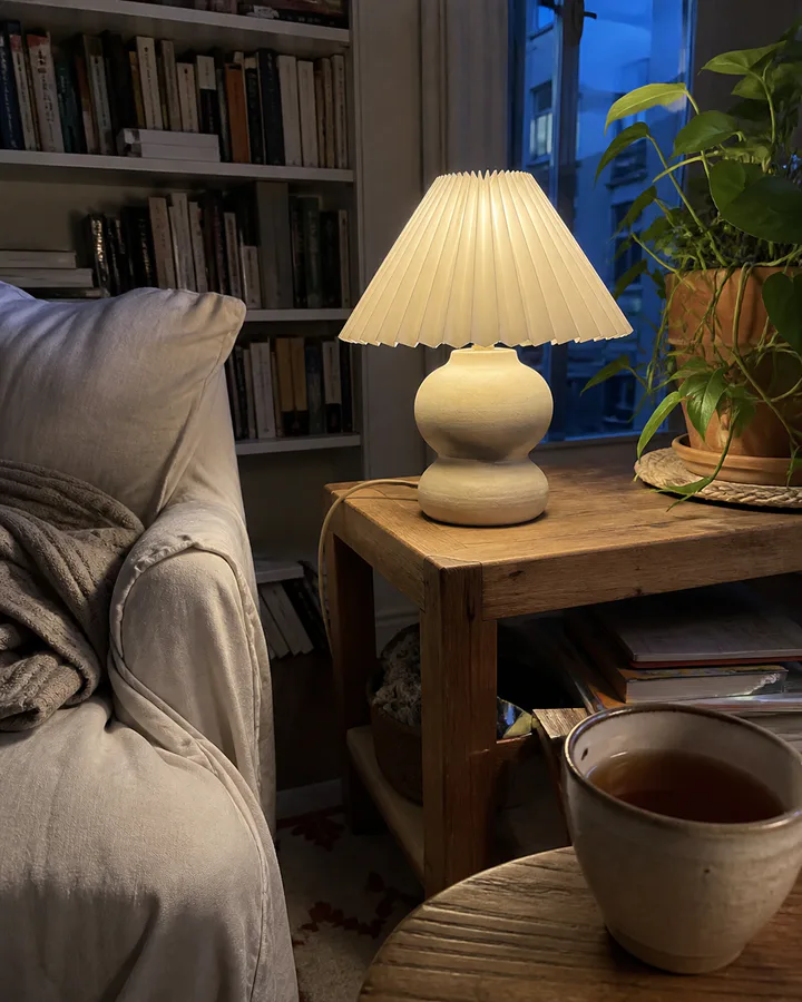 Customer photo of a cream table lamp glowing in a reading corner