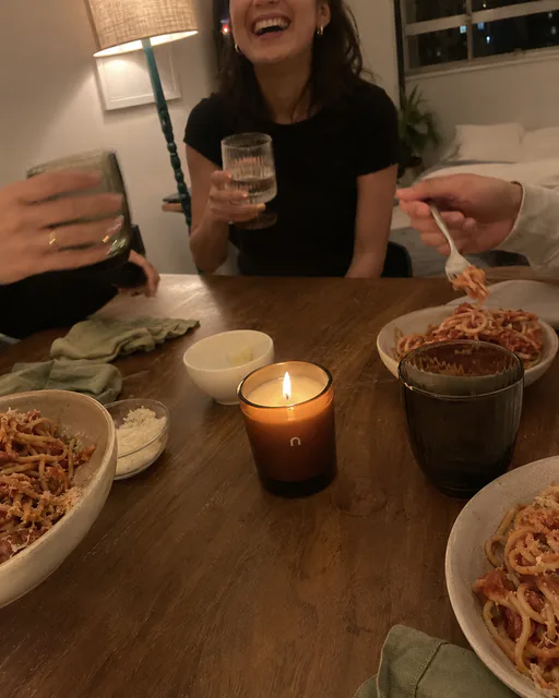 Arkadaşlarla yemek sırasında parlayan amber mum